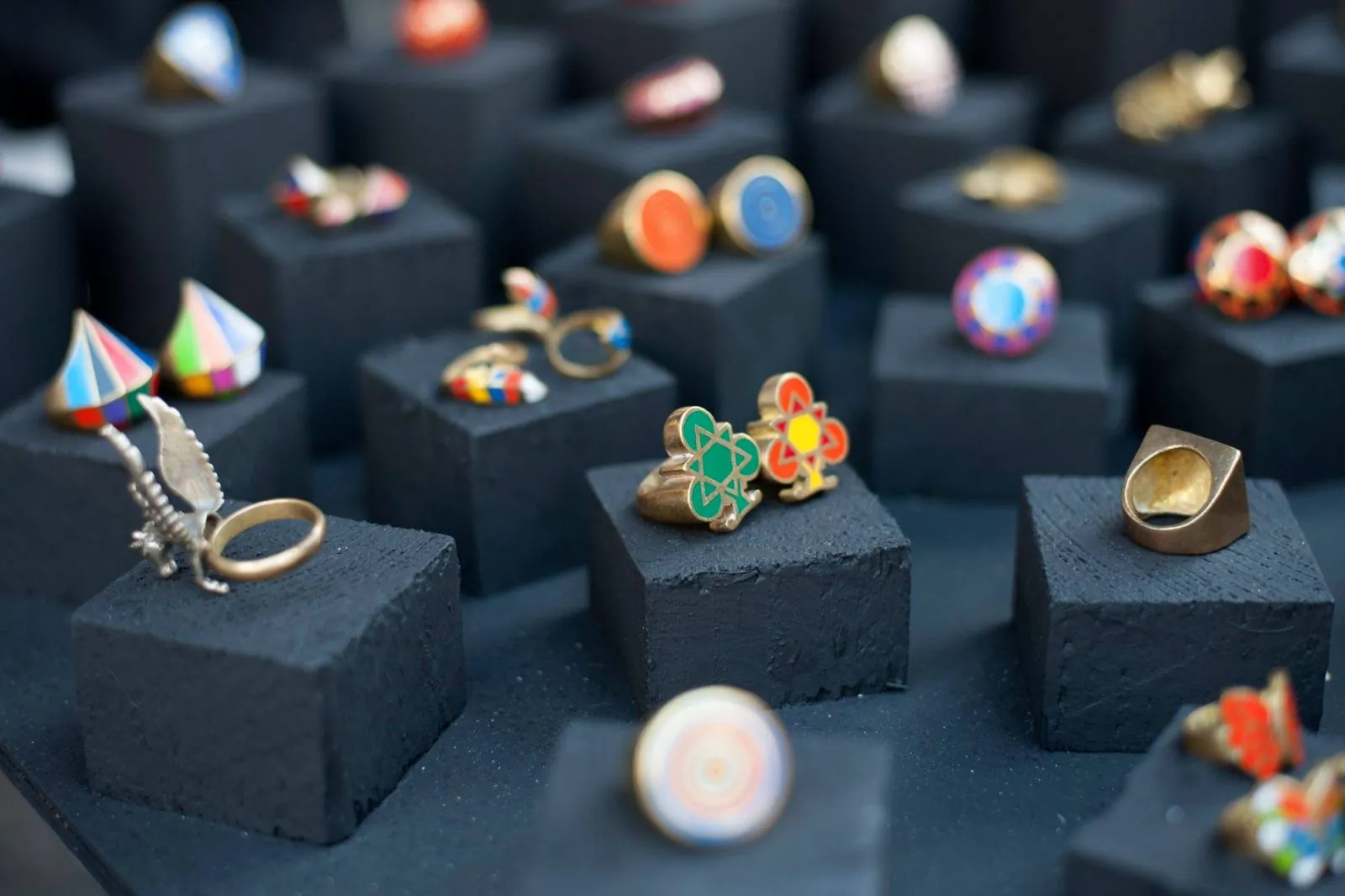 Handgefertigte bunte Ringe auf schwarzen Samtblöcken präsentiert