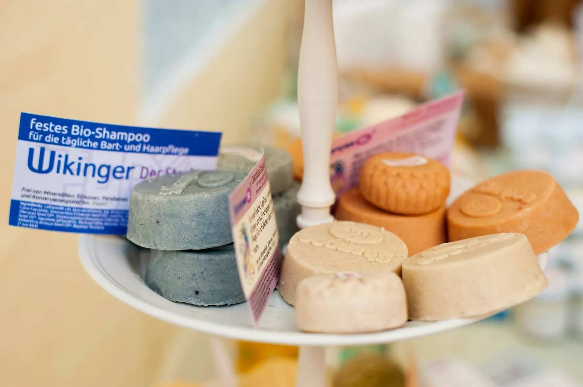 Feste Bio-Shampoo-Stücke in verschiedenen Farben auf einer Etagere