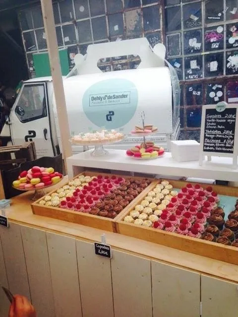 Verschiedene Sorten Cupcakes und Törtchen in Holzkisten und auf Etageren